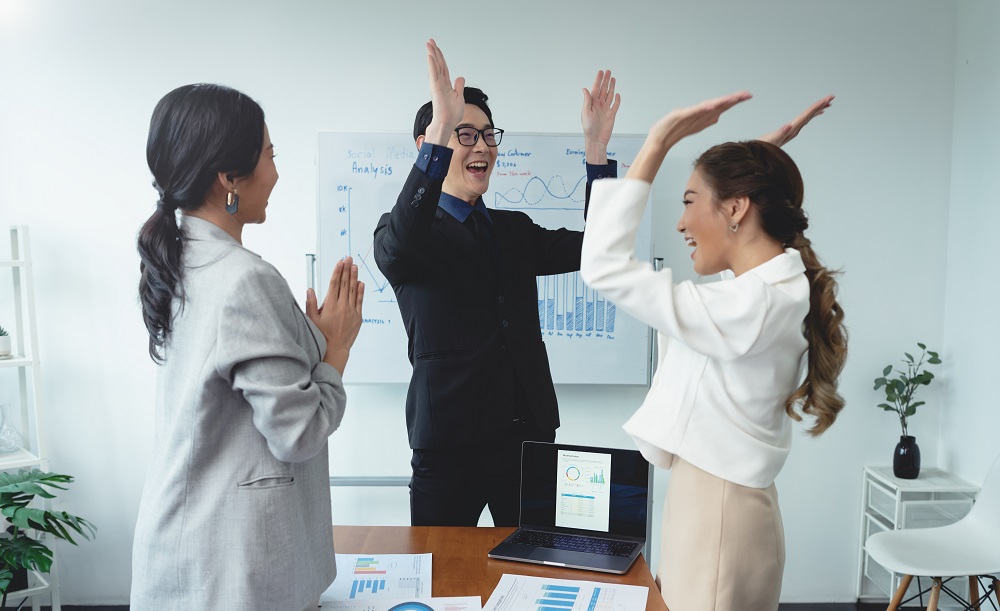 Group of people cheering over a successful project